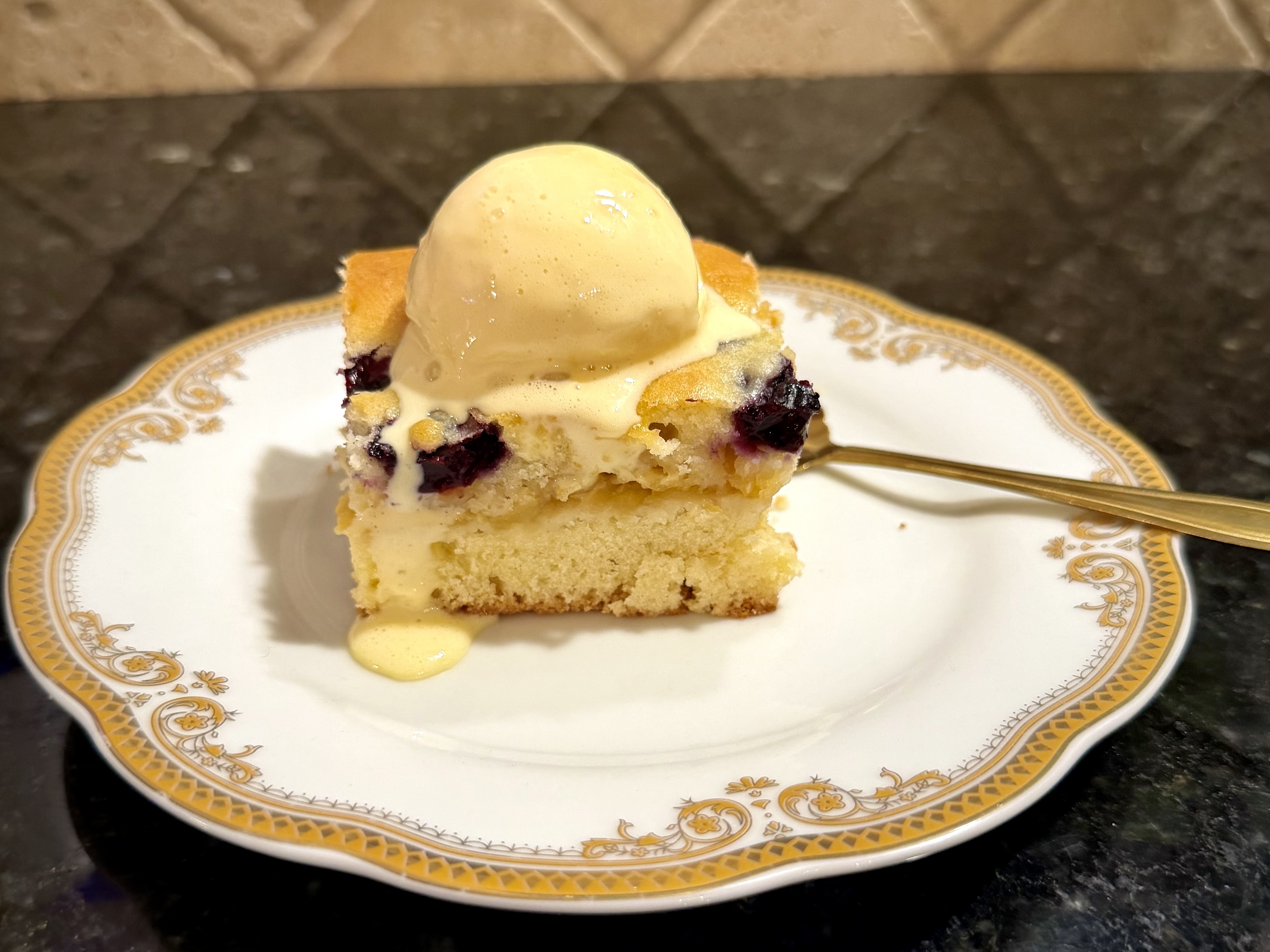 Slice of old-fashioned apple cake with blueberries showing the soft apple layer between two cake layers